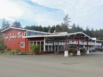 Capt. John's Motel building with cars parked outside.
