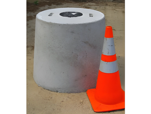 A gray concrete block with a circular top and metal fixtures