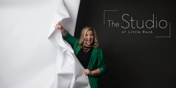 Woman pulling back a large white sheet, smiling.