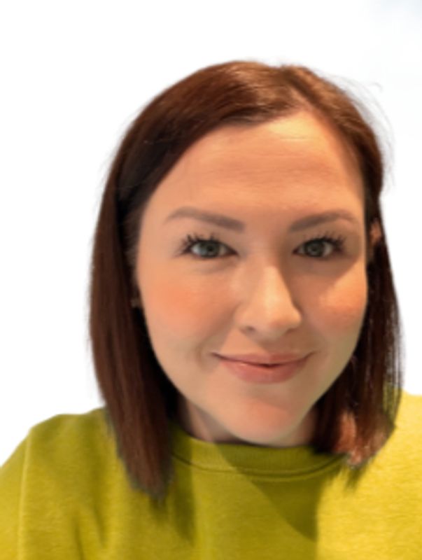 A woman with straight brown hair wearing a green top, smiling softly.