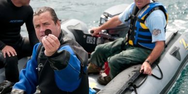 bradley williamson hold a silver coin, part of sunken treasure from shipwreck