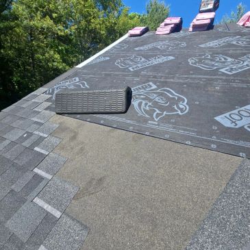Roofing work in progress with shingles and underlayment.