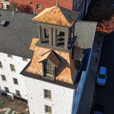 Aerial view of a building with a wooden shingle roof tower.