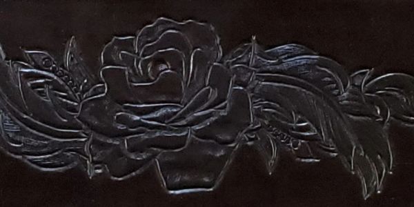 Carved western floral design with a rose and feathers.