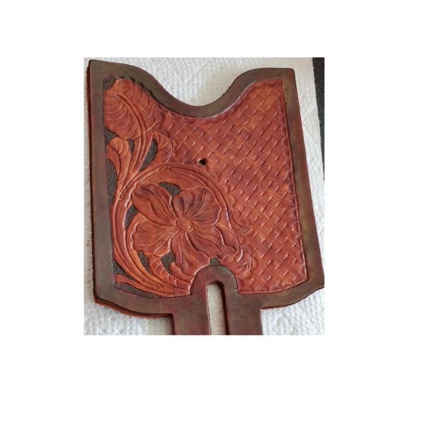Intricately tooled leather piece with floral and basketweave patterns.