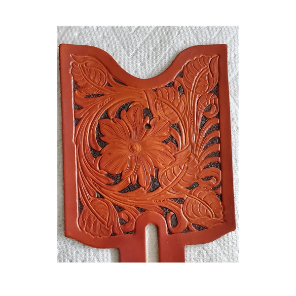 Intricately carved leather piece with floral and leaf patterns.