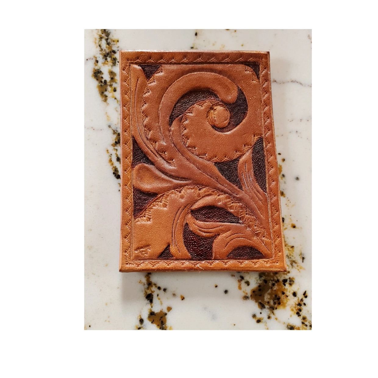 Intricately carved southwestern style trading card with western floral patterns .