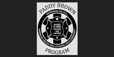 Emblem of the Paddy Brown Program with a protective shield and motto for service.