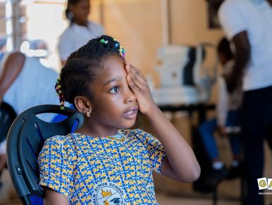 Young girl covering one eye during an eye checkup.