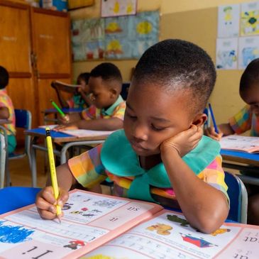 Child focused on writing in classroom.