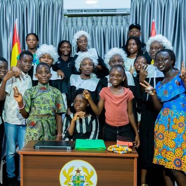 Group of children and teens posing in a mock courtroom.