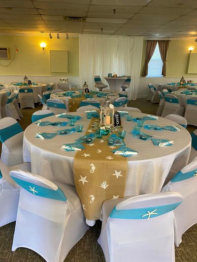 Beach-themed wedding reception setup with turquoise and white decor.