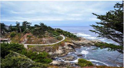 Scenic coastal pathway winding along rocky cliffs by the ocean.