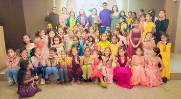 Group photo of children and adults in colorful clothing.