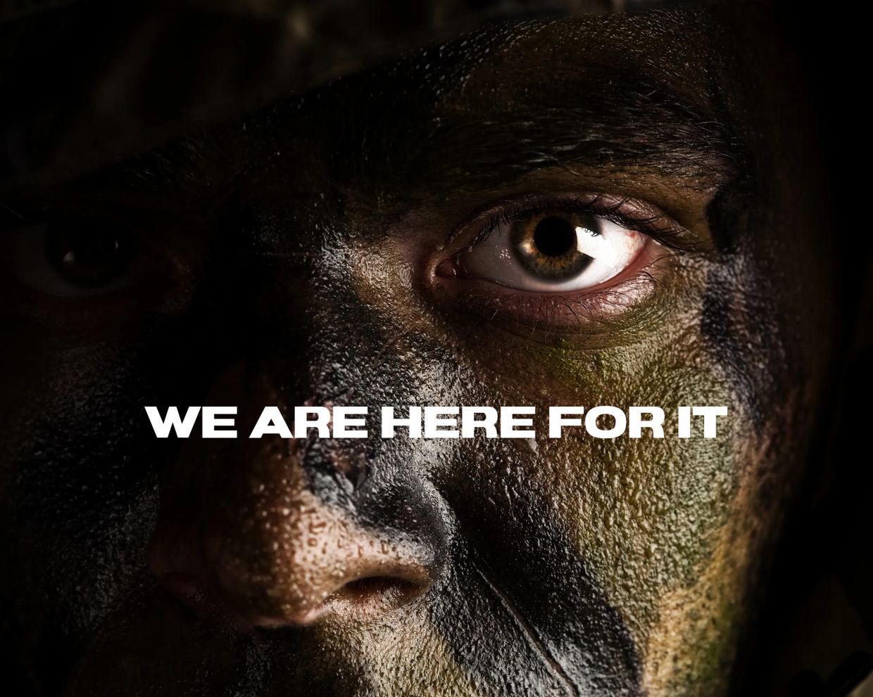 Close-up of a camouflaged soldier's face with intense eyes.