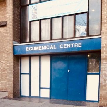 An old picture of the front of the centre, a mid blue door and sign with white accent. 