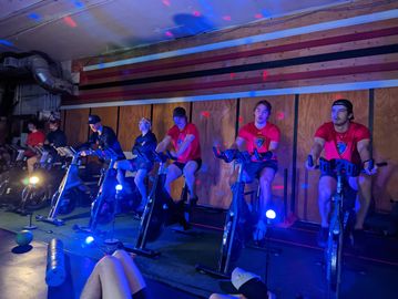 a hockey team rides bikes in a training session with spotlights