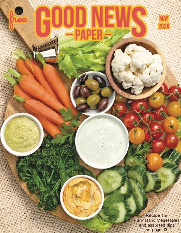 A vibrant vegetable platter with assorted dips on a wooden board.