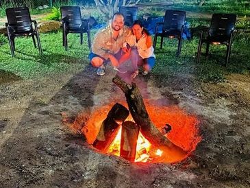 Guest enjoying and posing beside a warm fire camp at Namooru Hillview
