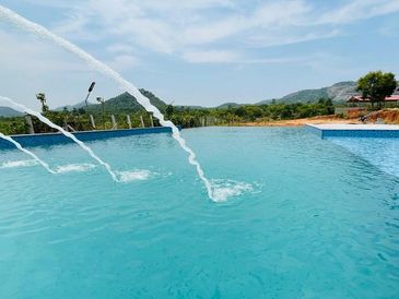 Inviting swimming pool at Namooru Ecostay, surrounded by lush greenery