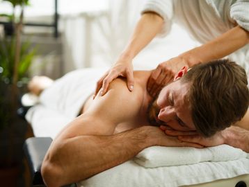 Man receiving a shoulder massage on a massage table.