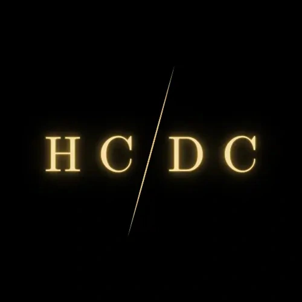 Golden letters 'HC/DC' separated by a diagonal line on black background.