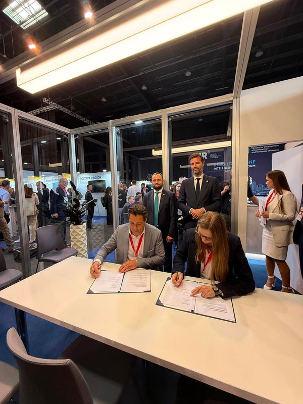 People signing documents at a formal event.