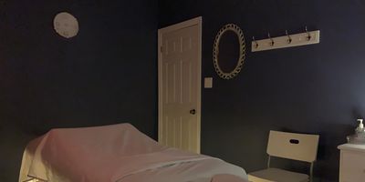 Dimly lit massage room with a massage table and relaxing ambiance.