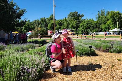 Occupational Therapist crouching with a child in a field of lavender