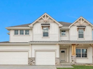 Modern two-story house with white siding and stone accents.