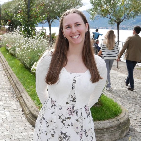 Smiling woman in floral dress outdoors.