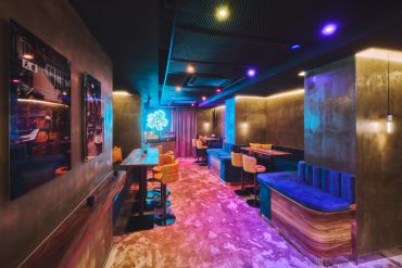 Modern neon-lit restaurant interior with vibrant seating.