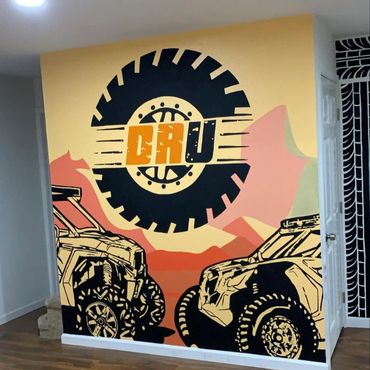 Custom ATV rental business mural featuring off-road vehicle artwork and bold branding.