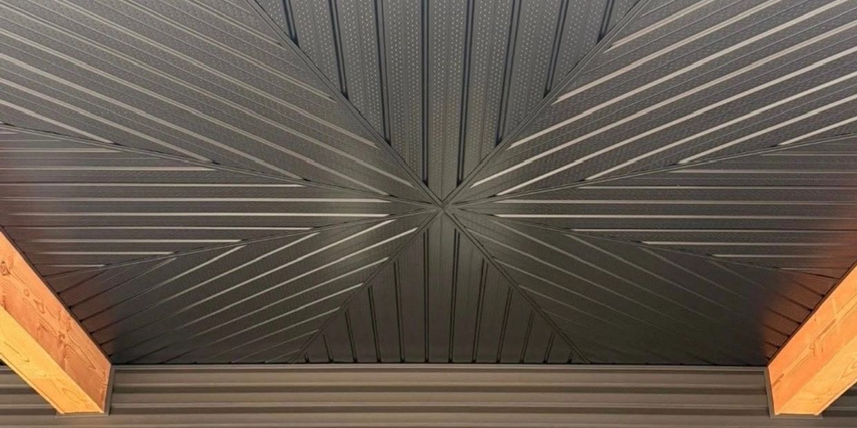 Intricately patterned ceiling with geometric design and wooden beams.