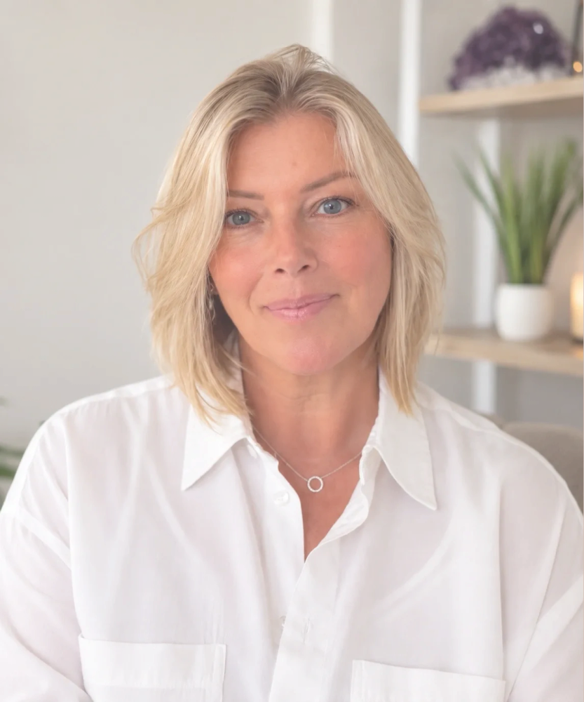 Smiling woman with blonde hair in a white shirt.