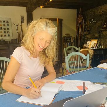 A woman working on her screenplay at home, in front of her computer. 