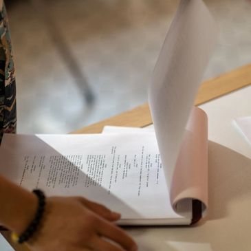 Person reviewing the screenplay on a clipboard.