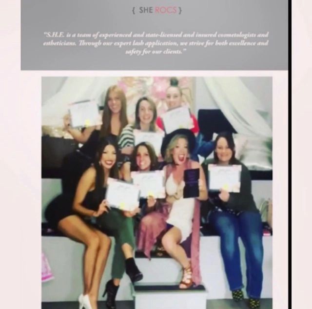 A group of seven women proudly holding certificates, celebrating achievements together.