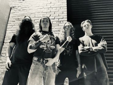 Black and white photo of four band members posing.