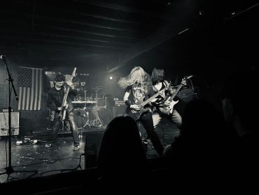 Black and white photo of a rock band performing on stage.
