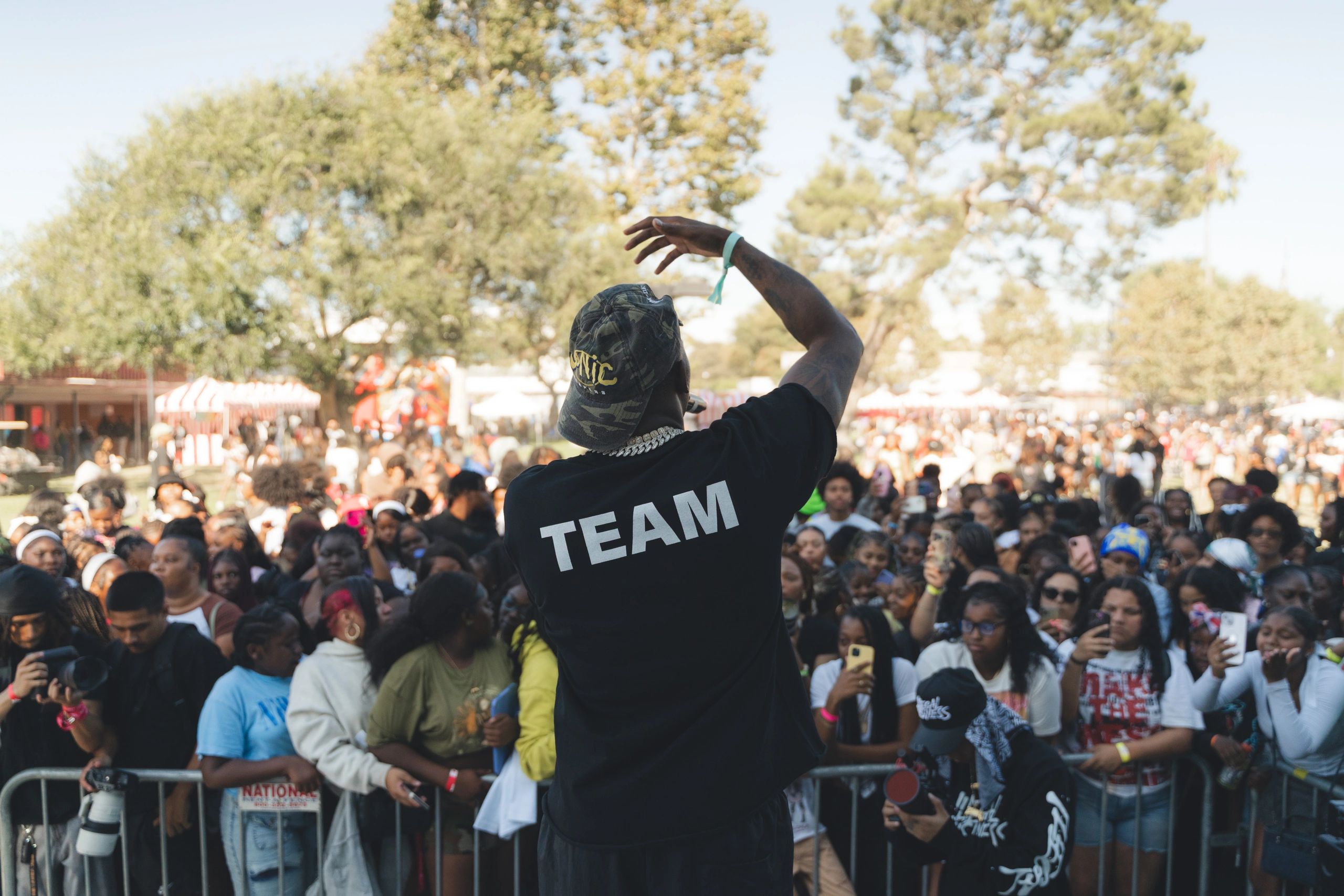 Performer engaging a large outdoor crowd at a daytime event.