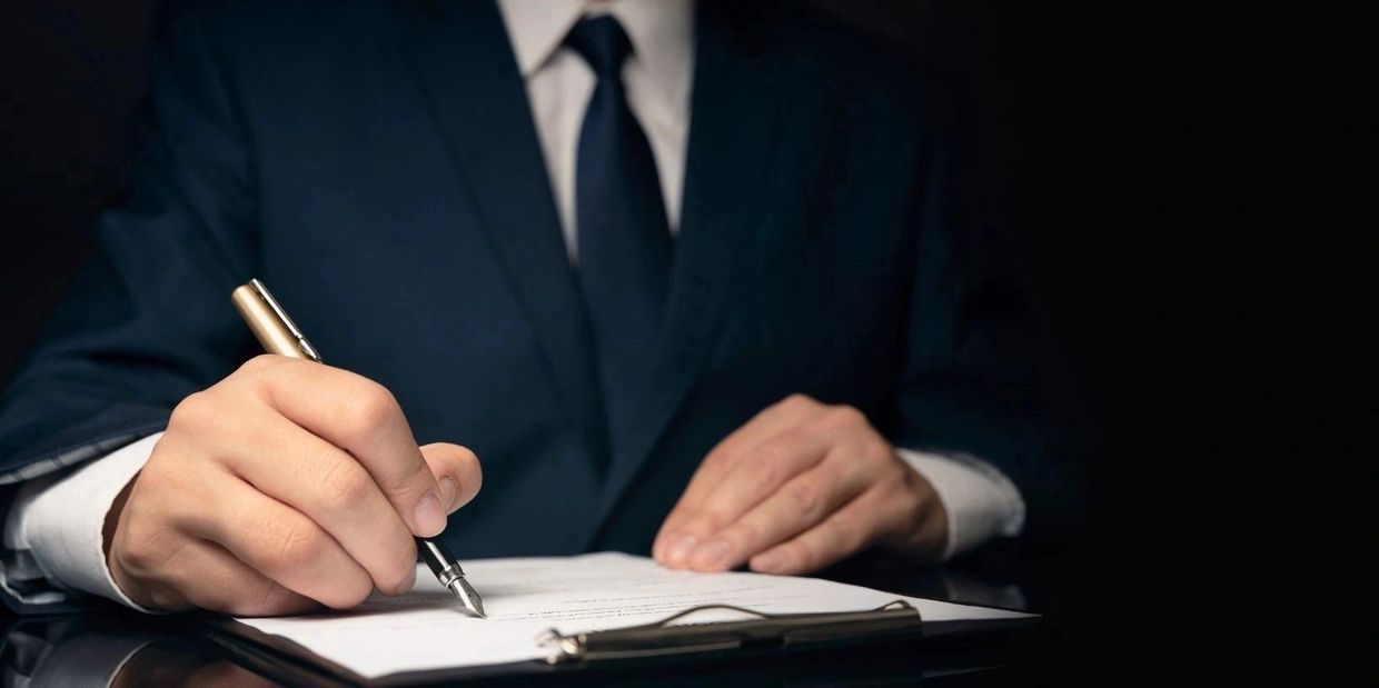 Hombre de negocios escribiendo en un portapapeles.