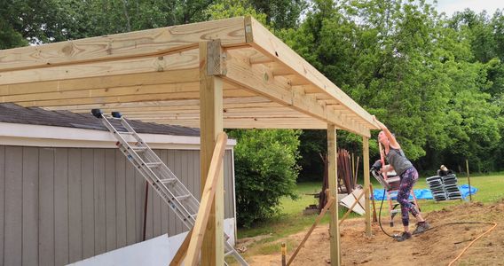 Crystal is nailing off sub fascia boards. This is on the Barnes Project in Sims, NC!