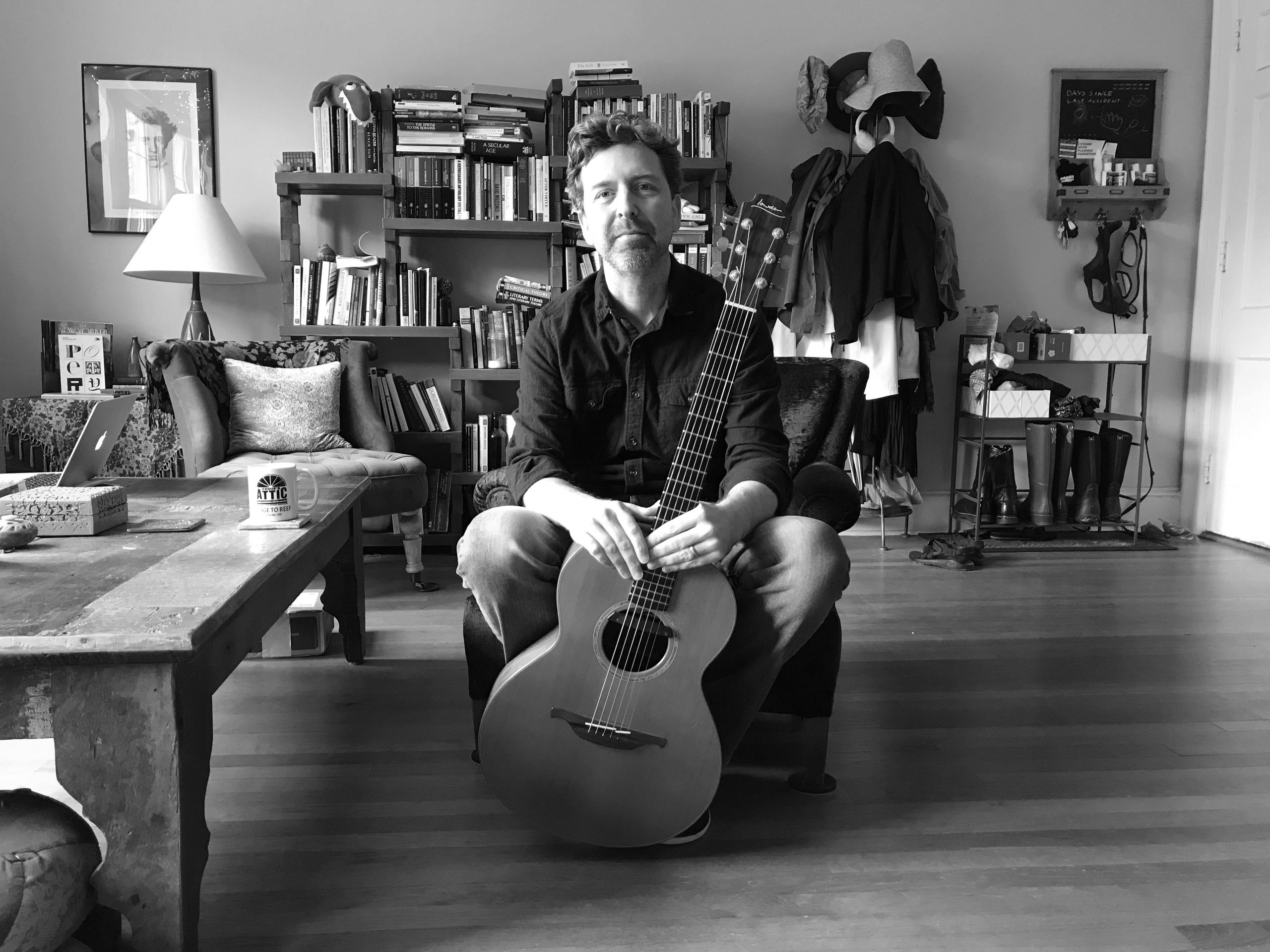 Colin Bragg at home with guitar