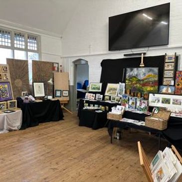 Art exhibit with various paintings and drawings displayed.