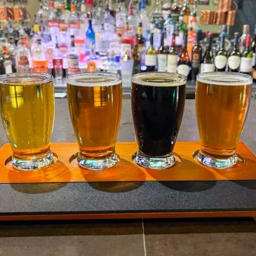 Four different beers in a tasting flight at a bar.