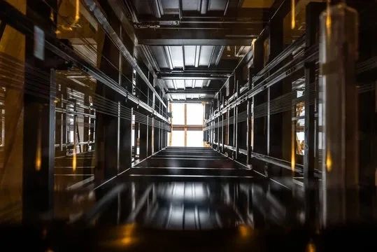 View looking up an elevator shaft with reflective surfaces.