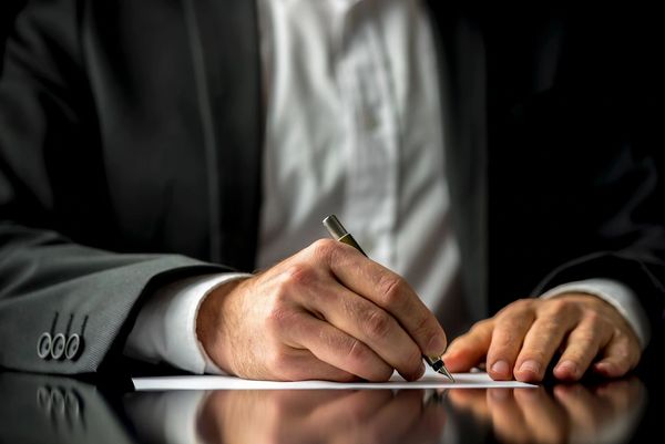 Conceptual image of a man signing a last will and testament document.