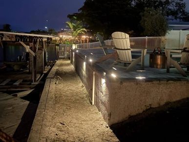 Outdoor patio area with chairs and lighting at night.
