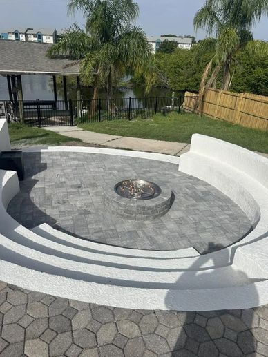 Curved outdoor fire pit with seating in backyard.